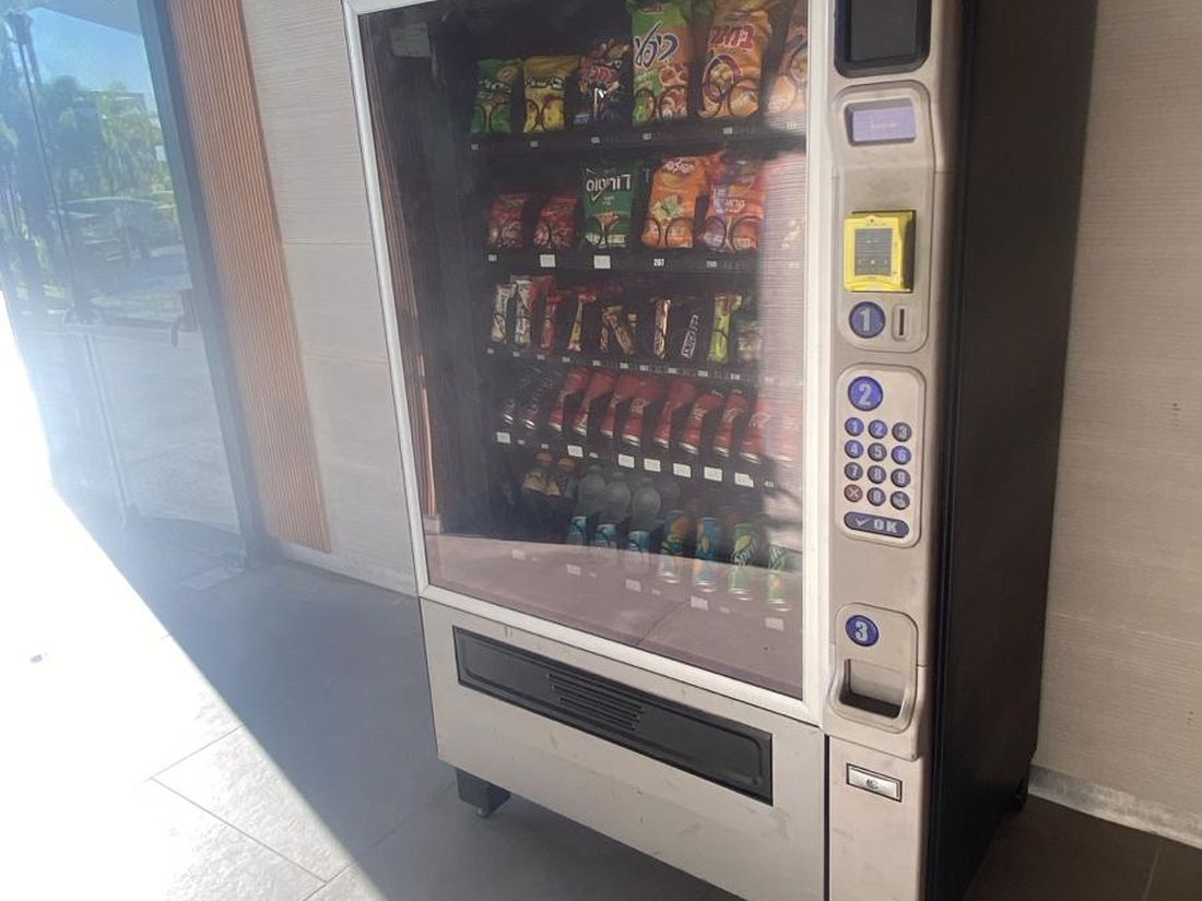 מכונת שתייה וחטיפים עומדת במסדרון מואר