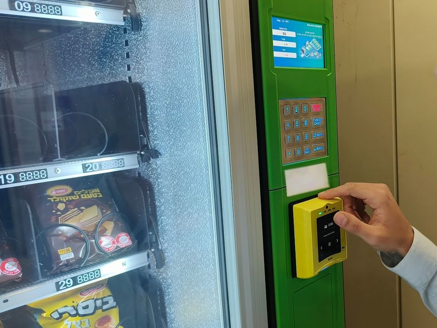 יד מעבירה אמצעי תשלום בקורא של מכונה אוטומטית